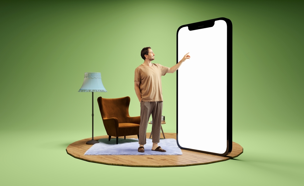 larger than life phone and man scrolling on it