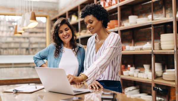 two woman looking at a laptop at their store